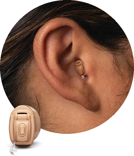 An ear with a Phonak completely in canal hearing aid deep in the canal, its removal cord just visible, and the hearing aid shown alongside